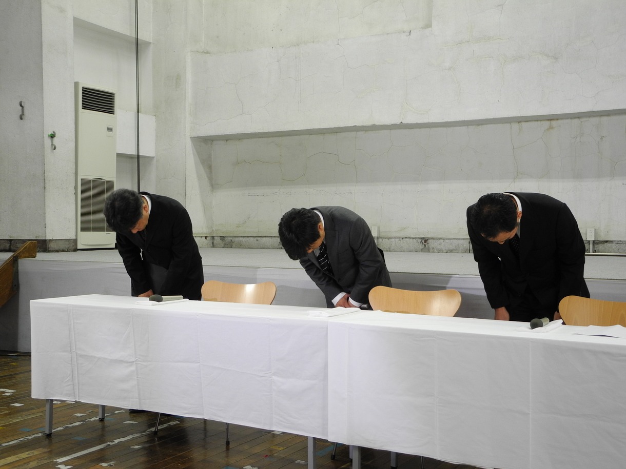 頭を下げる次長課長・河本（中央）、竹中功 よしもとクリエイティブ・エージェンシー専務取締役（左）、渡邊宙志 吉本興業法務本部長（右）。