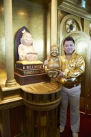 ビリパー兄さん像を手にするひらパー兄さんデラックス（ブラックマヨネーズ小杉）。