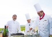 焼尻島の空の下で腕をふるう三國清三シェフ（左端）とタカ（右端）。(c)UHB/YOSHIMOTO KOGYO