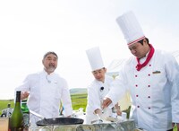 焼尻島の空の下で腕をふるう三國清三シェフ（左端）とタカ（右端）。(c)UHB/YOSHIMOTO KOGYO