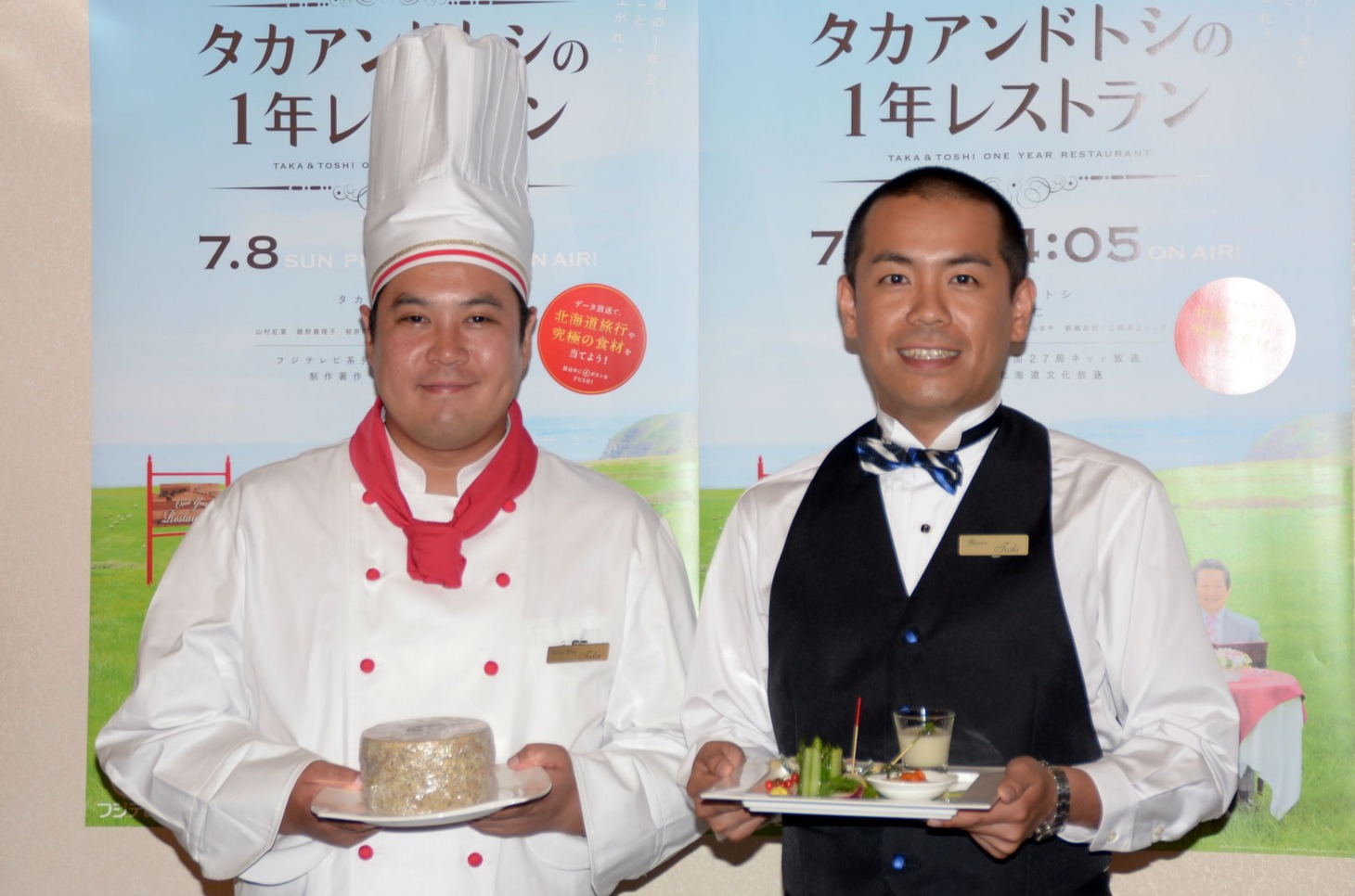 「タカアンドトシの1年レストラン」発表会見に出席したタカアンドトシ。タカ（左）はチーズ、トシ（右）はアスパラ料理と、それぞれ北海道グルメを手にしている。