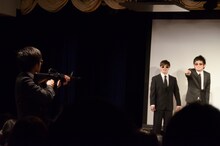 ザンゼンジ岡野を狙撃するべく、客席からステージへ銃を構える鬼ヶ島・おおかわら（左）。