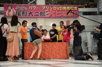 尾形のうどんに七味唐辛子を入れていく観客。