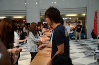 さわやかな表情で来場者と握手する尾形。