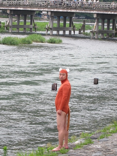 渡月橋をバックにかわうそ君。「この写真のために大昔からあったかと思うと痛快」と渡月橋に対して上から目線。