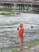 渡月橋をバックにかわうそ君。「この写真のために大昔からあったかと思うと痛快」と渡月橋に対して上から目線。
