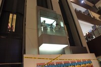 ガラス張りのエレベーターに乗って登場するバナナマンと大島麻衣。