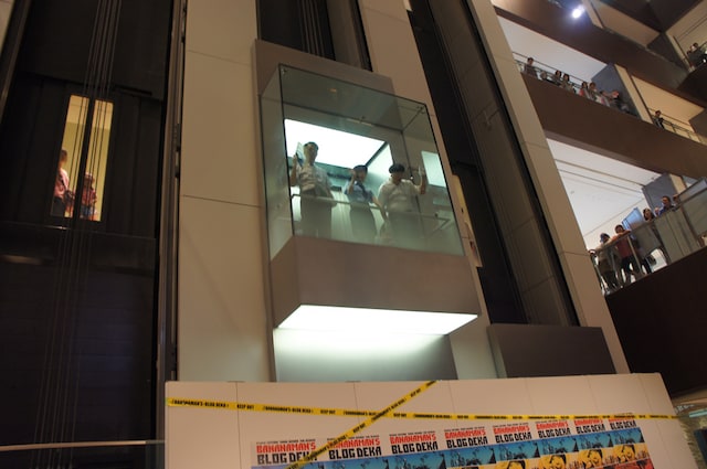 ガラス張りのエレベーターに乗って登場するバナナマンと大島麻衣。