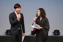 イベントMCのあべこうじ（左）とピース又吉（右）。