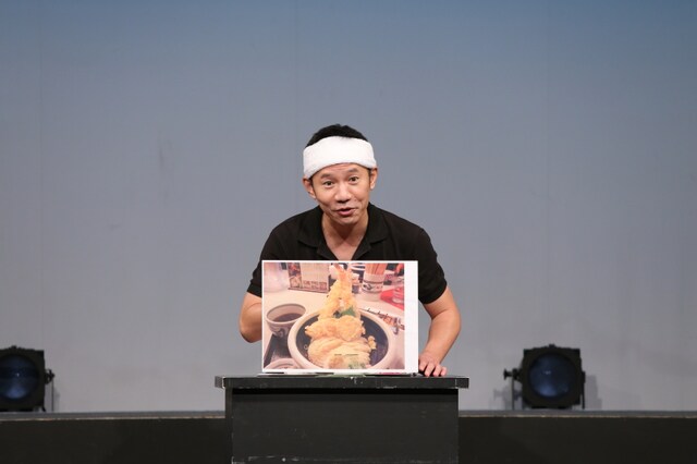 オモロー山下。写真は2012年8月のイベントで全国の変わり種うどんを紹介したときのもの。