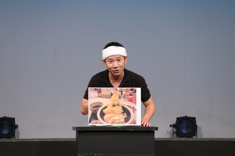 オモロー山下。写真は2012年8月のイベントで全国の変わり種うどんを紹介したときのもの。