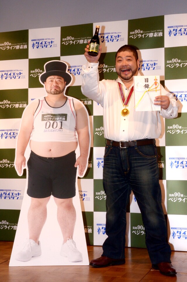 「ダイエットマラソン2012」で約16kgの減量に成功し、見事優勝した髭男爵・山田ルイ53世。左はダイエット前に撮影された写真パネル。