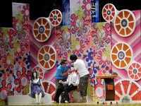 スタジオセットに置かれた白シャツ白ネクタイのマネキンが気になる2人。