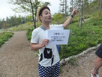 ハイキングを盛り上げるための指令を掲げた天狗・横山。(c)吉本興業