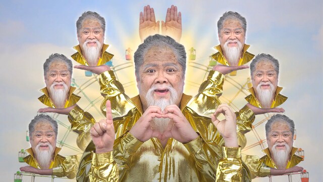 新CM「ひらかたパーク 祝100周年」編に出演する「ひらパー兄さんDX」ことブラックマヨネーズ小杉。千手観音のようになり、手文字で「100」を表現する。