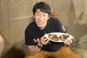 切りわけた肉を手に写真撮影に応じるジモン。