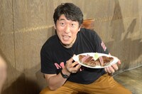 切りわけた肉を手に写真撮影に応じるジモン。