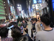 仮装大賞のような行列と、藤森と初恋タローのロケを見物する行列の人々。