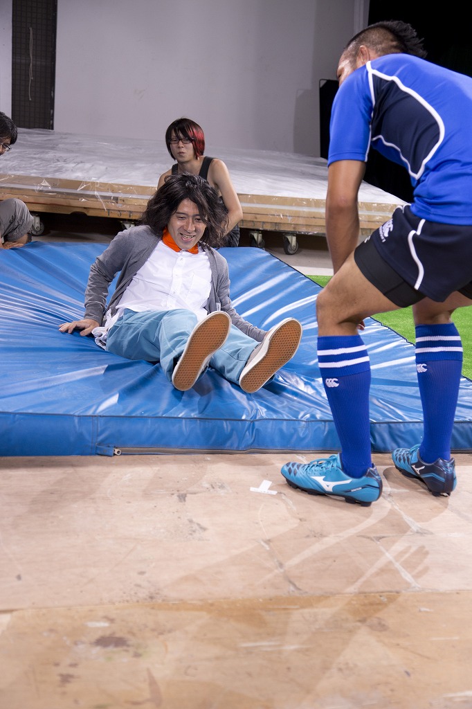 「突然ラガーマンにタックルされる」場面の撮影風景。