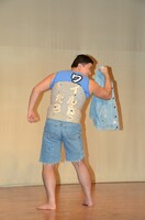 コルセットの下に「ワイルドだろ」とプリントされたシャツを着ているスギちゃん。