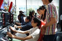 レーシングゲームに挑戦する出演者達。(c)ひかりTV