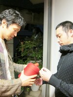 打ち合わせをする城氏の後ろに怪しい人影。