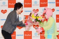 花子（右）に花束を手渡す夫・福島氏（左）。