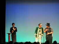 2人の後ろにはそれぞれワイングラスを置くための台座が。ワインを注ぐソムリエ的な係は、後輩芸人のこぶしが担当。