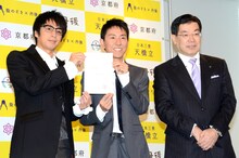 「京都府観光大使」の委嘱通知書を手渡されたチュートリアルと、京都府の山田知事（右）。