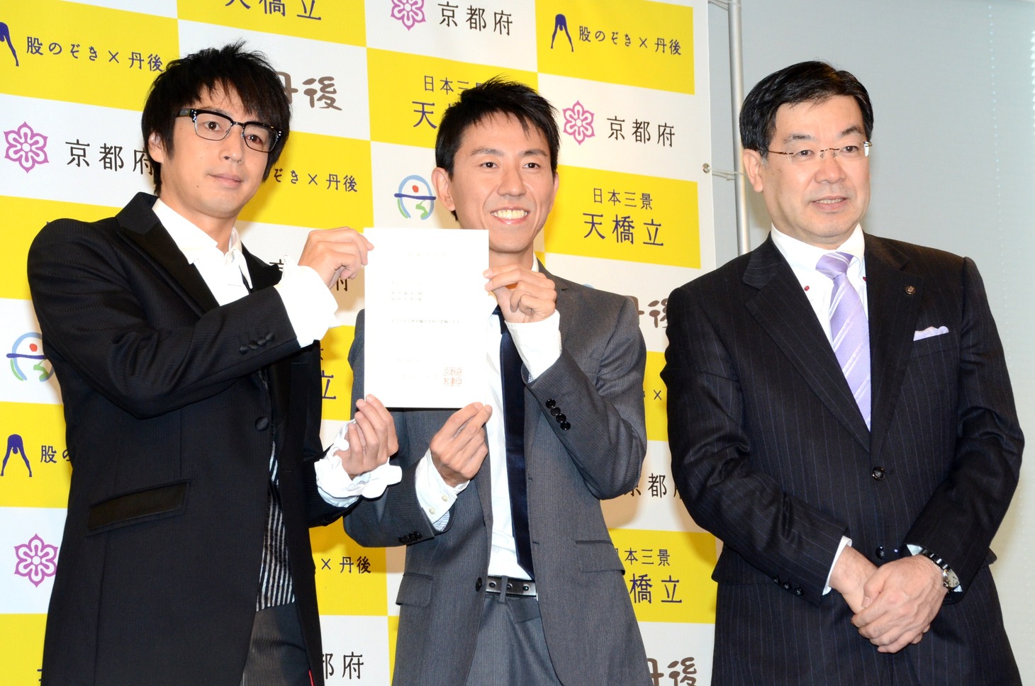「京都府観光大使」の委嘱通知書を手渡されたチュートリアルと、京都府の山田知事（右）。