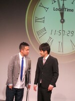 時計を背にカウントダウンの瞬間に向けて漫才を披露したなすなかにし。