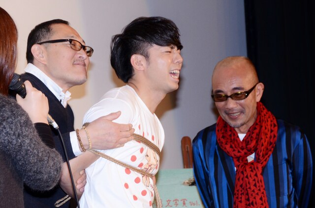 「緊縛師」の奈加あきらに「後手縛り（ごてしばり）」で念入りに縛られ、悶絶するピース綾部（中央）。