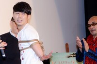 完成した「後手縛り」を見せる綾部と、拍手を送る竹中監督（右）。