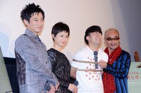 写真撮影の様子。綾部（右から2人目）1人だけ縛られているが、ほかの3人も服の中で密かに縛られていることがこの後明かされた。