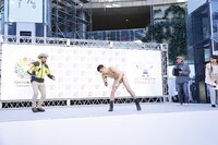 冬の屋外にもいつもの海パン姿で登場した小島（中央）。