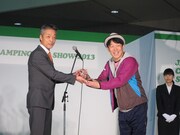 「第一回 キャンピングカーアワード」のトロフィーを満面の笑みで受け取るヒデ。