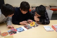 「これ誰だ？」と写真の人物を確かめ合う3人。