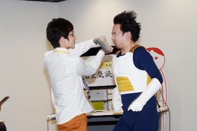 西村ヒロチョ（左）にハリセンで顔を叩かれるR藤本（右）。