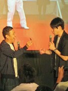 大使の名刺を吉村に嬉しそうに見せる岡村。