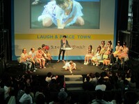 佐藤聖羅のセクシーポーズ。舞台の最前列には徳井。