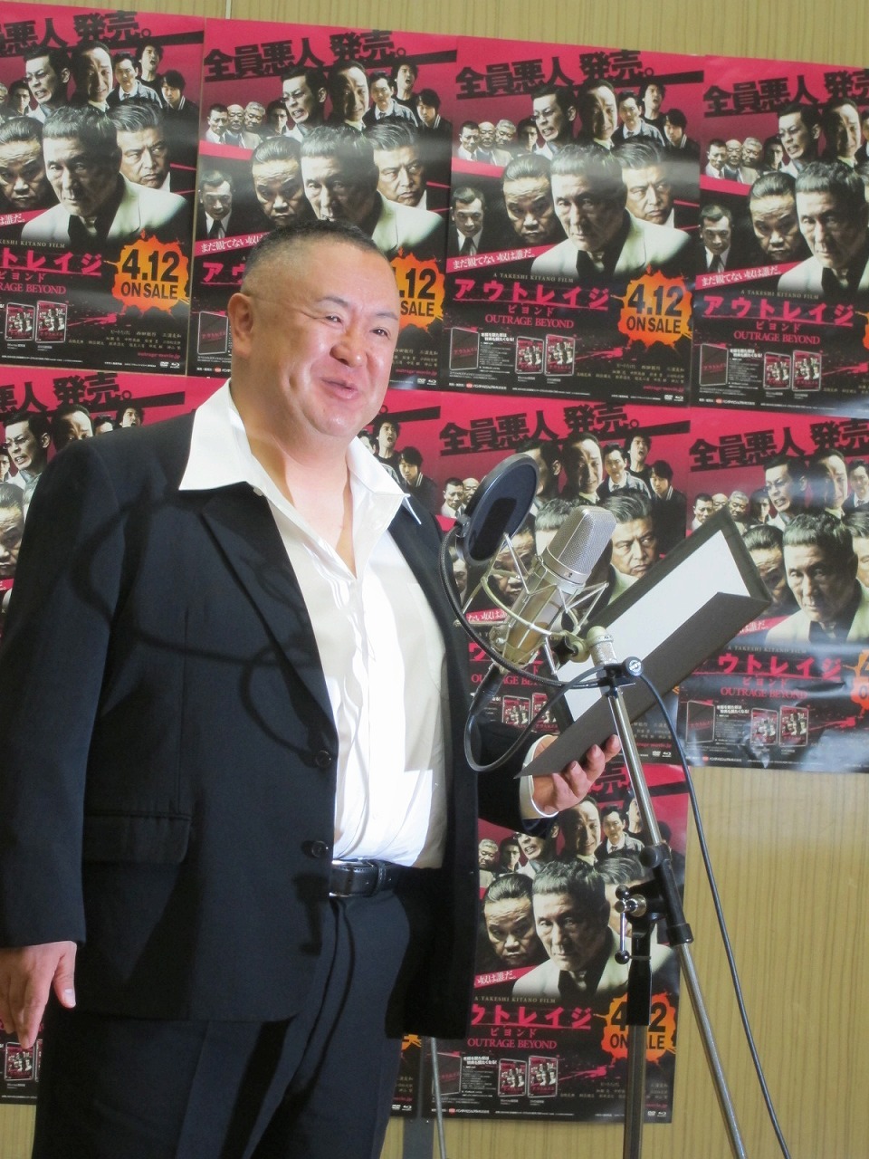 「悪人全員集合!! 松村邦洋 Presents “エイプリルフール”公開収録アフレコイベント」で映画「アウトレイジ ビヨンド」DVD＆Blu-rayのCMアフレコ収録を1人で行った松村邦洋。