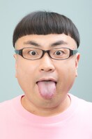 写真は「神の舌の飴＆アクションカード」。90×140mmのポストカードと約2cmの飴2個入り。台紙ではイジリー岡田が、高校3年生当時のバストアップ写真をプリントしたTシャツを着用している。どんな写真かは買った人のお楽しみだ。630円（税込）。