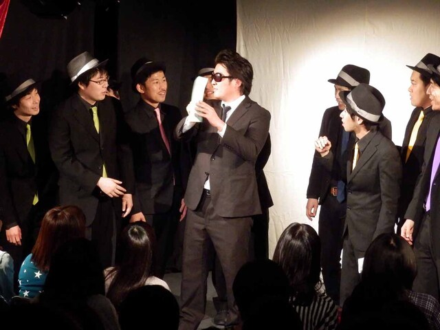 罰ゲーム執行人から封筒を渡されるピテカントロプス（左）。