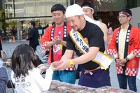 集まった一般客に焼き鳥をふるまうケンドーコバヤシ。