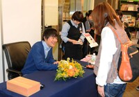 ファンの名前を聞きながら丁寧にサインしていくバカリズム。