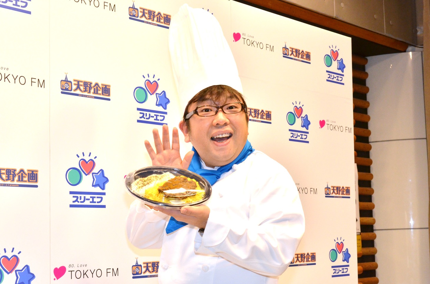 自身が出演するラジオ番組「天野企画」とスリーエフによるコラボメニューのプロデュースを務めたキャイーン天野。手にしているのは「えっ！逆カレー」。