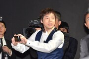 説明会中に壇上から降り、来場者の写真を撮影する今田耕司。