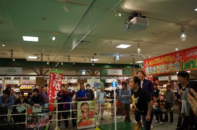 よしもと47ご当地市場にて行われた山形県寒河江市のご当地イベント「さくらんぼの種吹きとばし大会」。(c)吉本興業