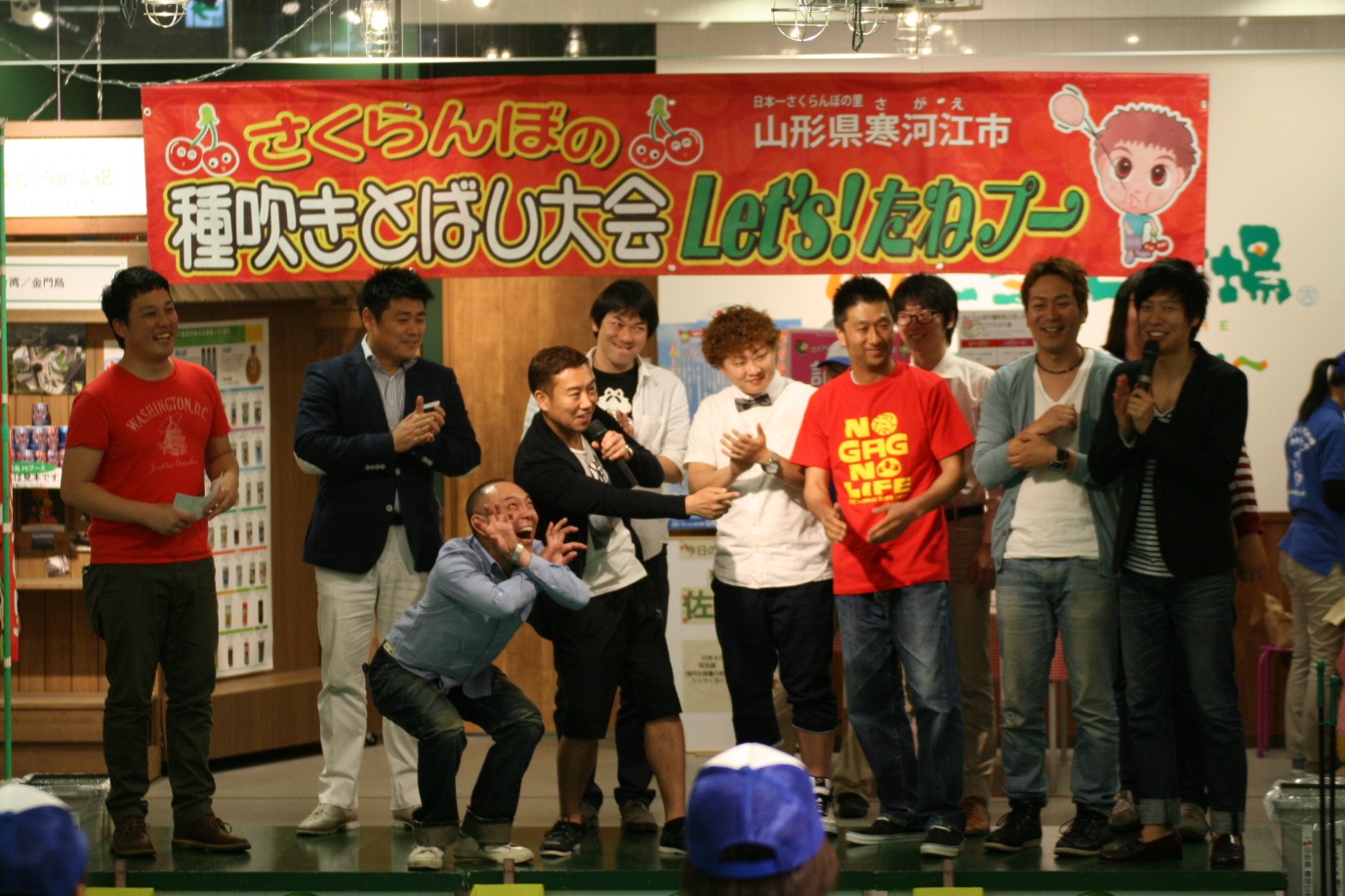 よしもと47ご当地市場にて行われた山形県寒河江市のご当地イベント「さくらんぼの種吹きとばし大会」。(c)吉本興業