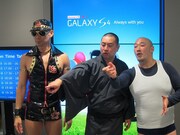 「GALAXY S4」を試しに来た人たちと会話するレイザーラモンとくまだまさし。